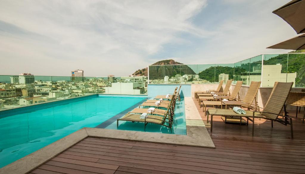 里约热内卢美洲科帕卡巴纳酒店 的大楼内一个带桌椅的游泳池