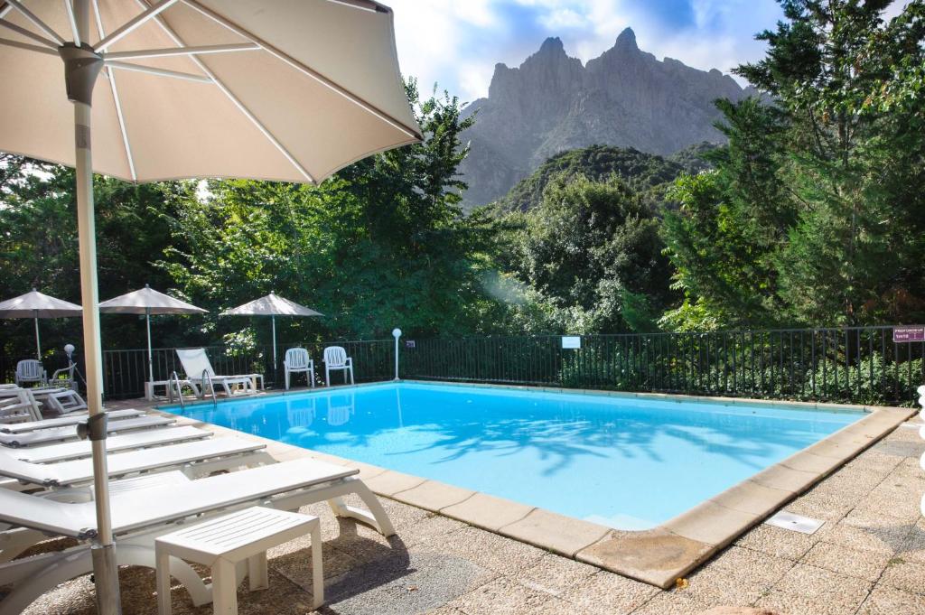 波尔图卡拉迪索酒店和公寓的一个带椅子和遮阳伞的游泳池