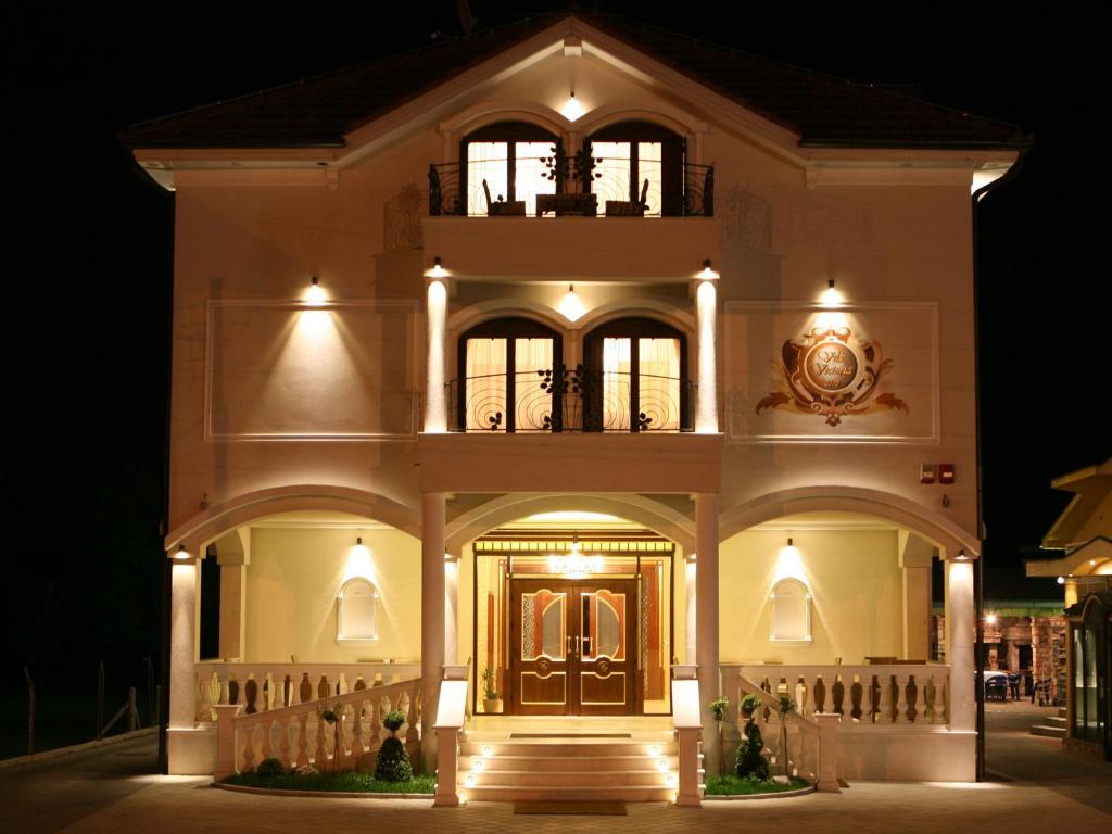 巴尼亚卢卡维多利亚别墅酒店的一座在晚上有前门的大建筑