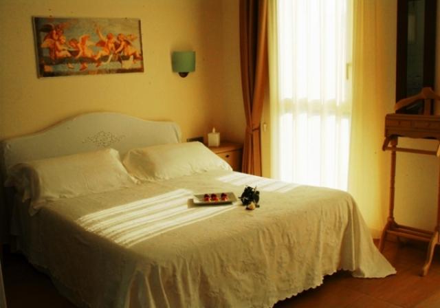 Villongo SantʼAlessandro皮克洛普林西比酒店的一张白色的床,上面放着一盘食物