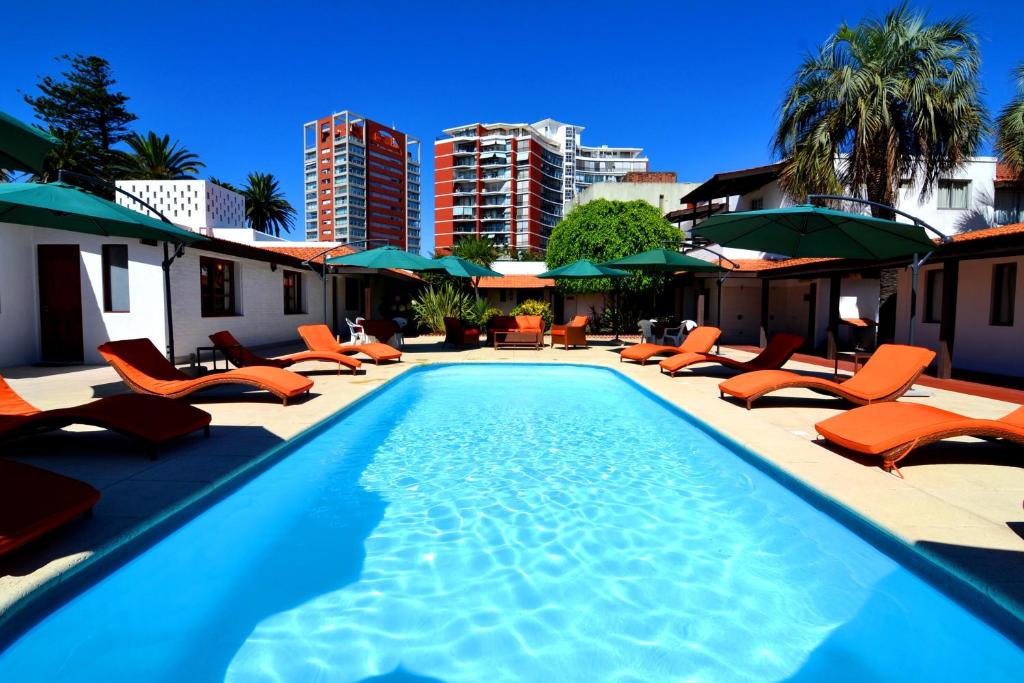 埃斯特角城协和酒店的一个带橙色躺椅和遮阳伞的游泳池