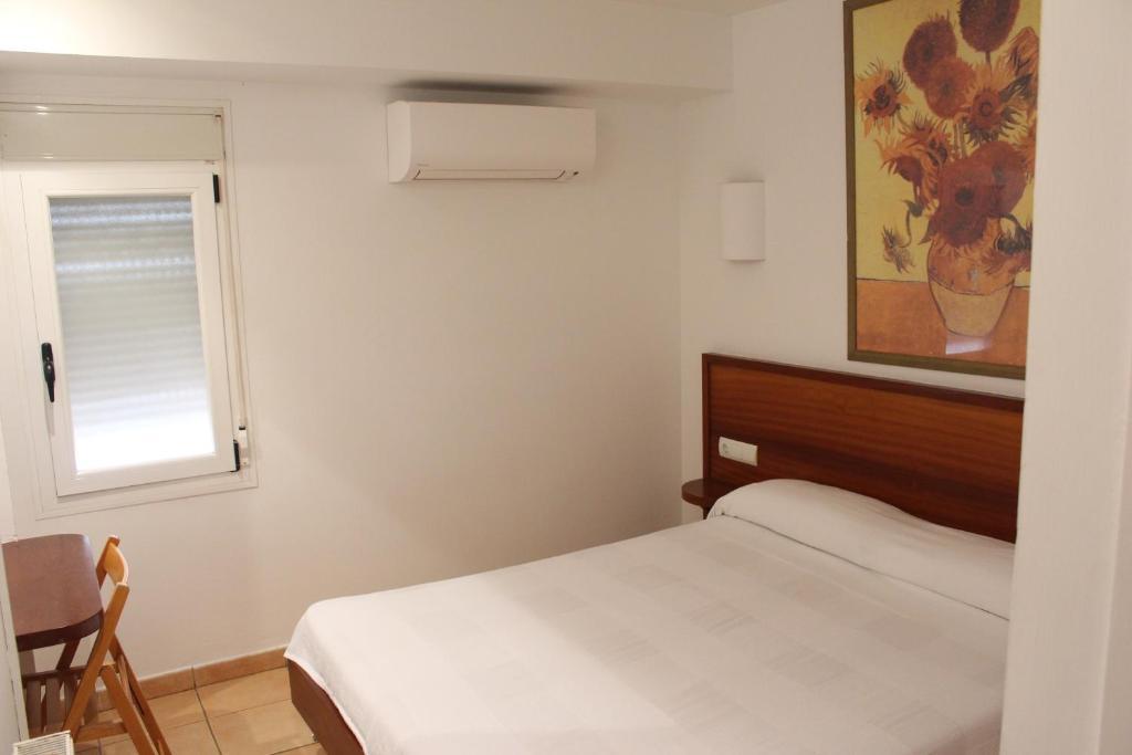 卡达克斯Hostal Cristina的一间小卧室,配有床和窗户