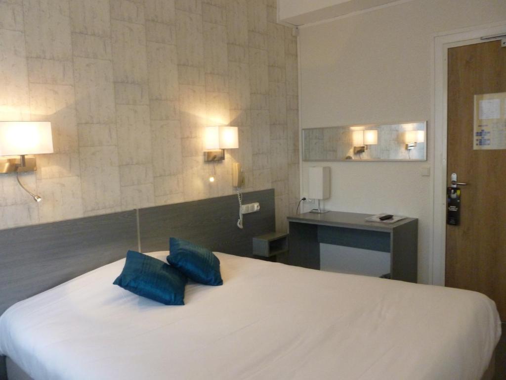 勒阿弗尔Hôtel LeRichelieu, Le Havre Centre-Ville的一间卧室配有一张带蓝色枕头的床。