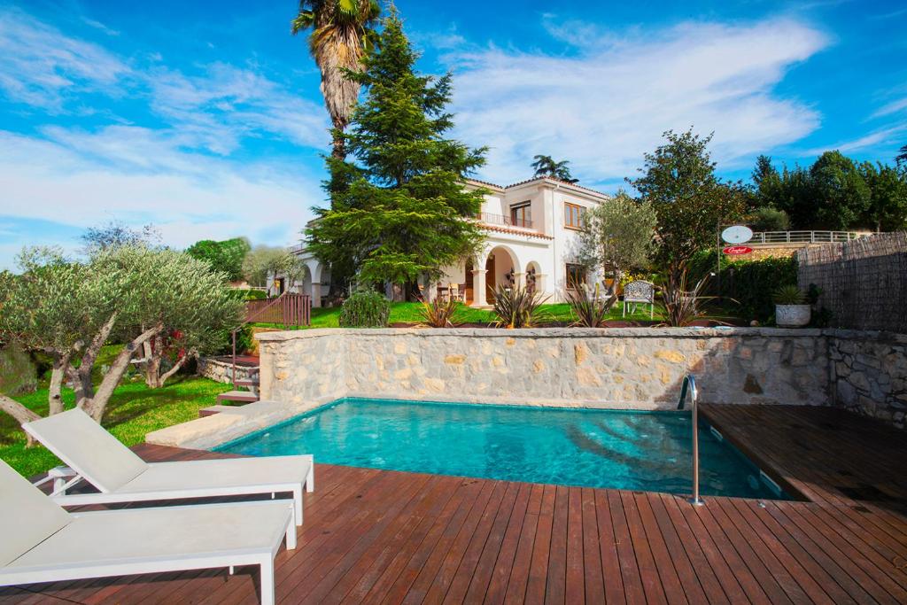 赫罗纳Villa Montjuic Girona的一座带游泳池和房子的度假屋