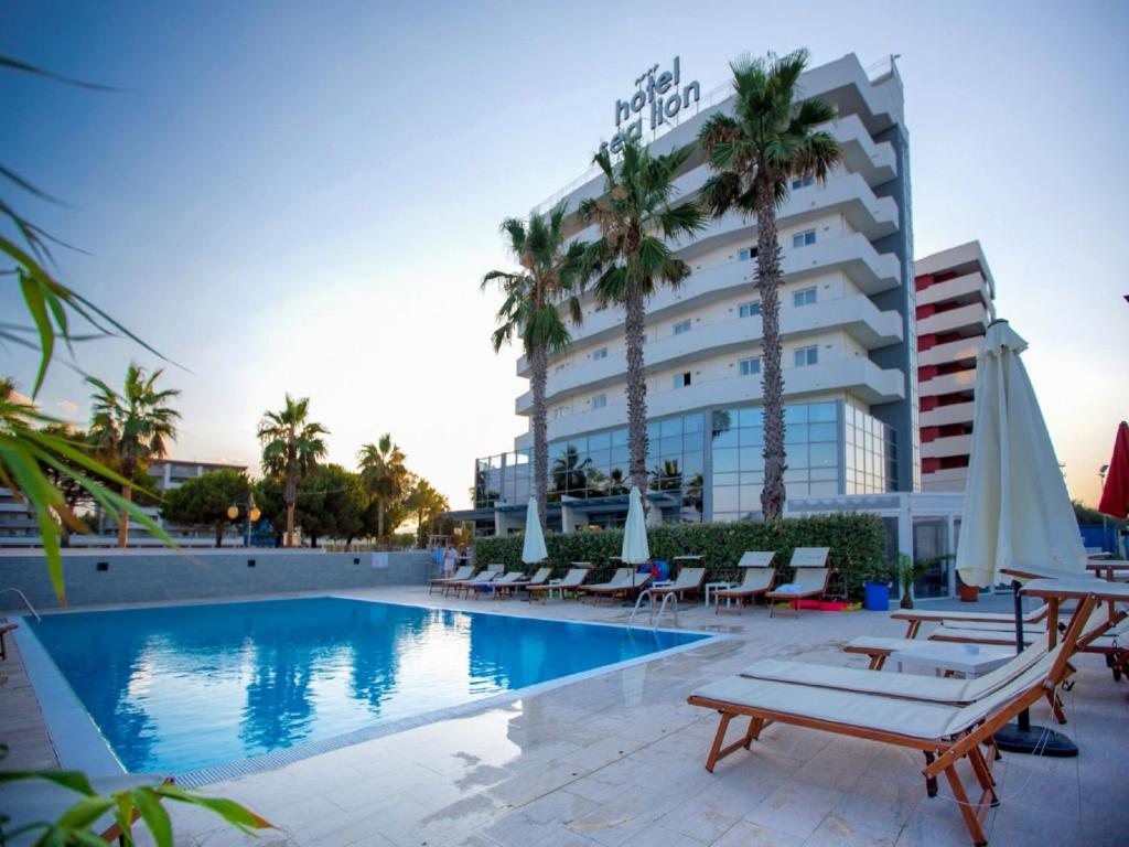 蒙特西尔瓦诺海狮酒店的一座拥有游泳池、椅子和棕榈树的酒店