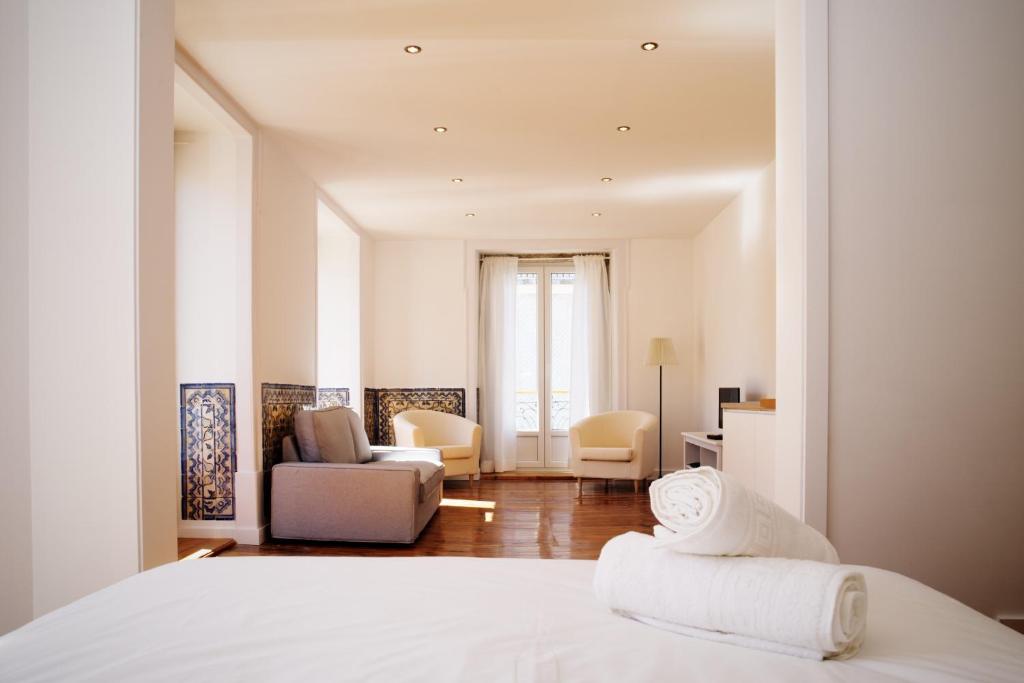 里斯本GS希亚多精品一室公寓及套房的一间卧室设有一张床和一间客厅。