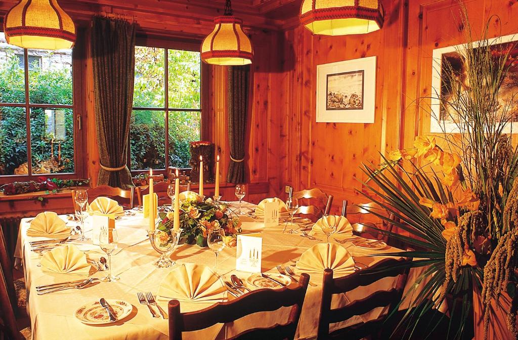 舍姆贝格奥赫森兰德加特酒店的用餐室配有带鲜花和蜡烛的长桌