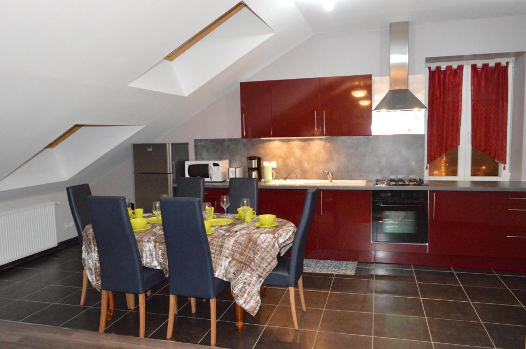 热拉梅Rochire Location 1的一间带蓝色椅子的桌子的厨房和一间带红色橱柜的厨房