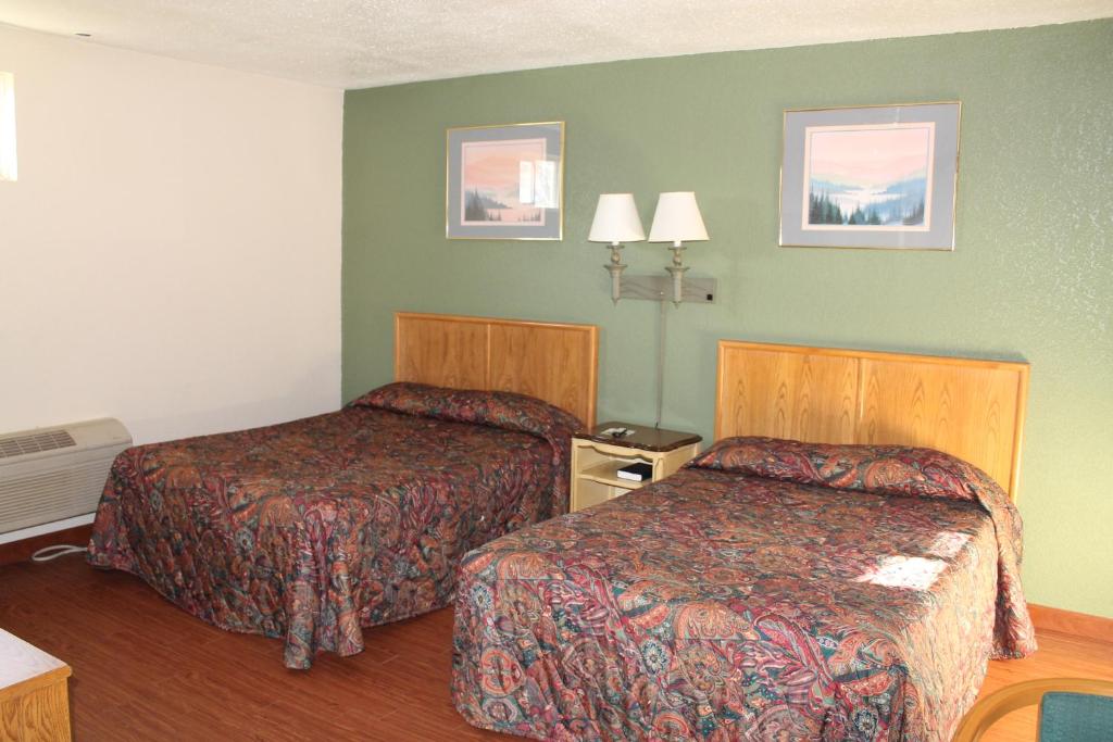罗克艾兰美国汽车旅馆 - 罗克岛的一间酒店客房,设有两张床和绿色的墙壁