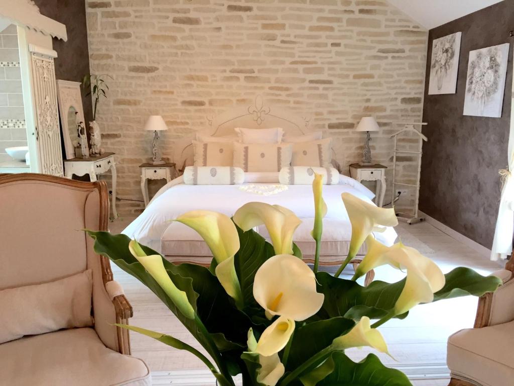 Campagne-lès-HesdinChambres d'hôtes Nuits Campagnardes的卧室配有白色的黄色鲜花床
