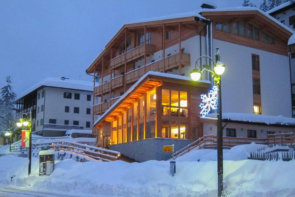 摩德纳迪-坎皮格里奥Hotel Garnì Caminetto的一座晚上下雪的建筑