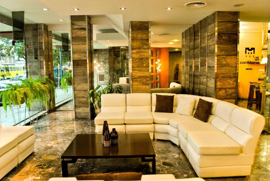 罗萨里奥Hotel Mayoral的客厅配有白色的沙发和桌子