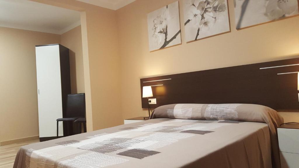 维拉弗兰卡宾纳戴斯阿维尼达旅馆的一间卧室配有一张大床和黑色床头板