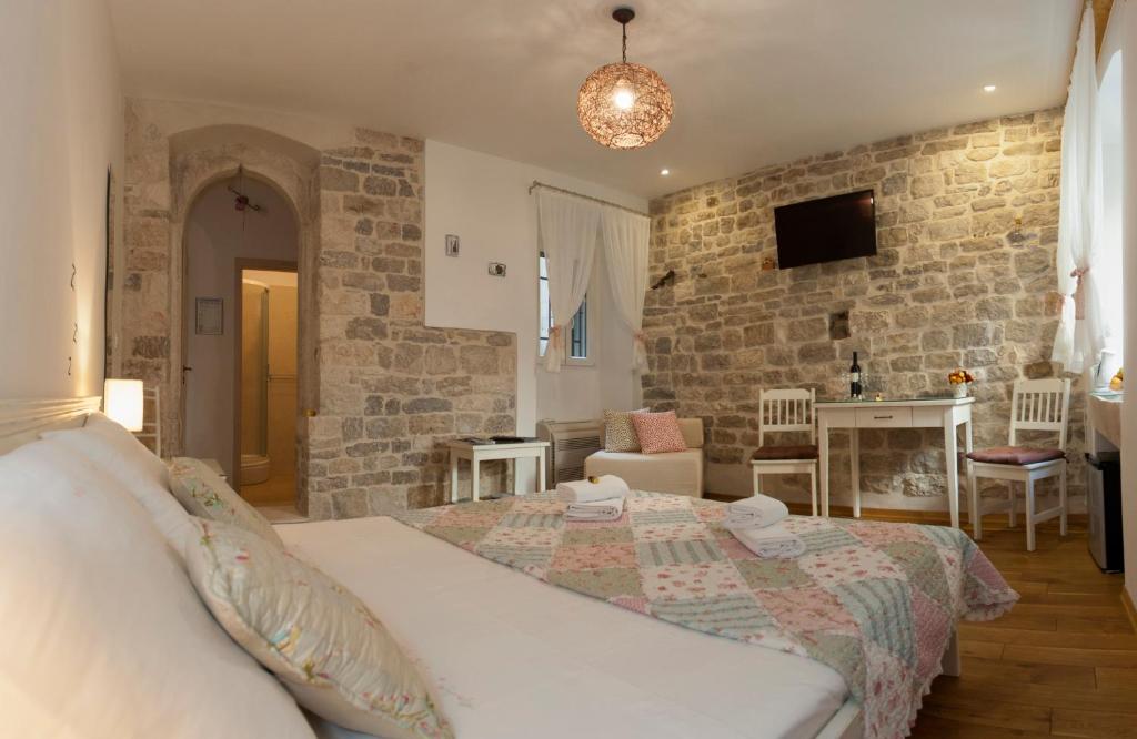 斯普利特科科拉旅馆的一间卧室设有一张床和石墙