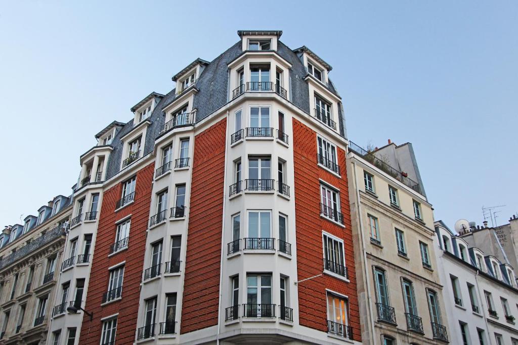 巴黎Pick A Flat's Apartments in Saint Michel - Rue Du Sommerard的一座高大的砖砌建筑,上面设有阳台