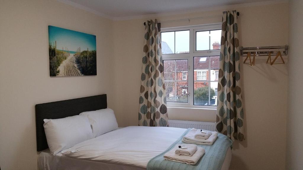 牛津牛津之家旅馆的一间卧室配有床和带毛巾的窗户。