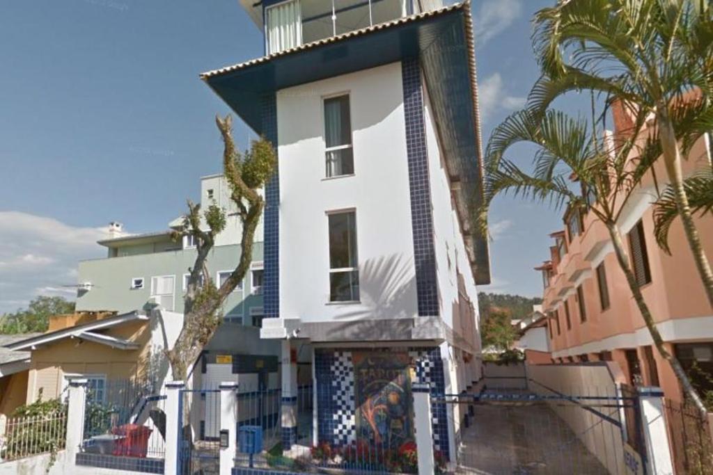 弗洛里亚诺波利斯Tarot Residence的一座白色的建筑,前面有棕榈树