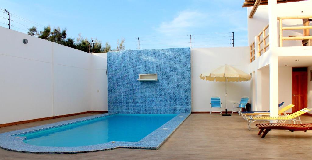帕拉卡斯Caihuayna Apart Hotel的蓝色墙壁旁的一座房子,设有游泳池