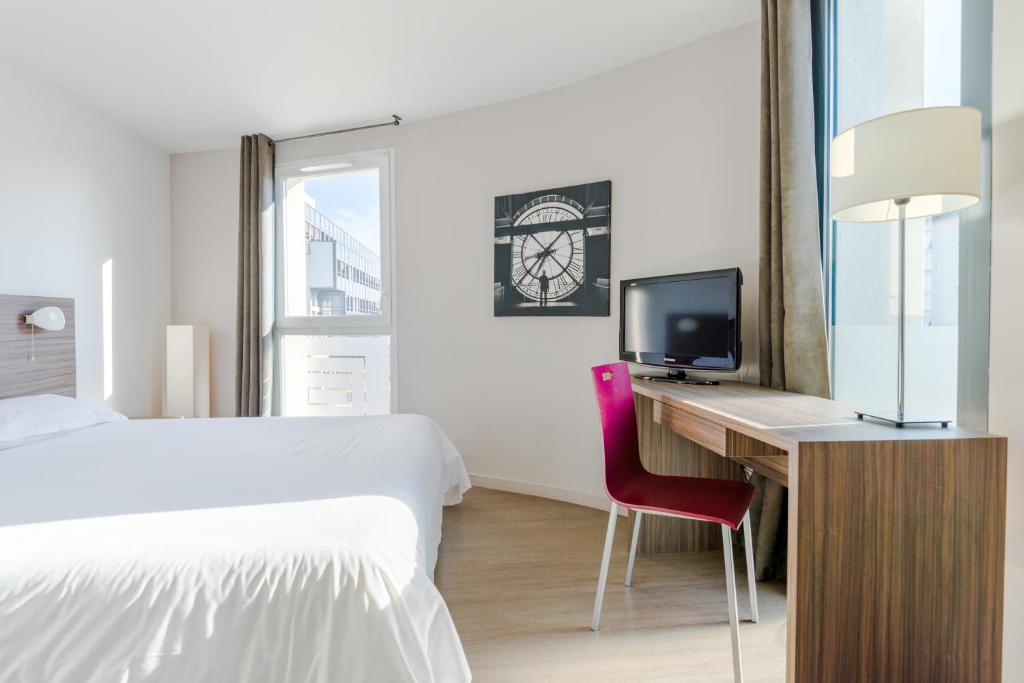 瓦朗斯厄瓦酒店的一间卧室配有一张床和一张书桌及电视