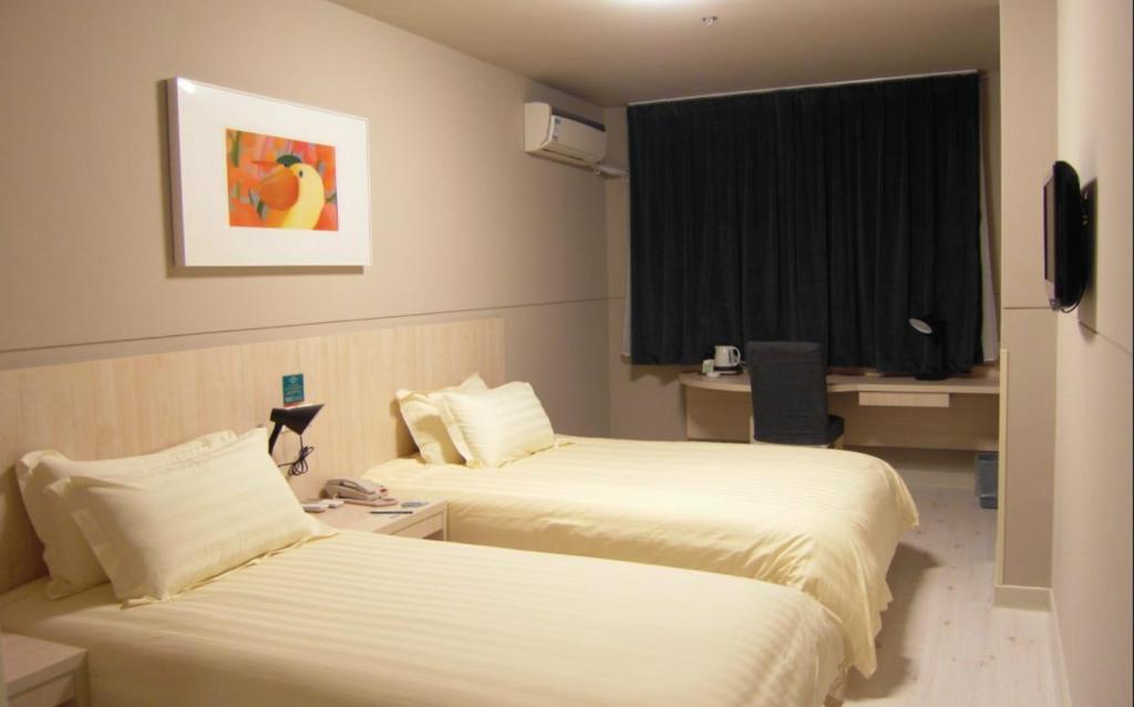 延吉锦江之星延吉火车站市政府酒店的酒店客房设有两张床和窗户。