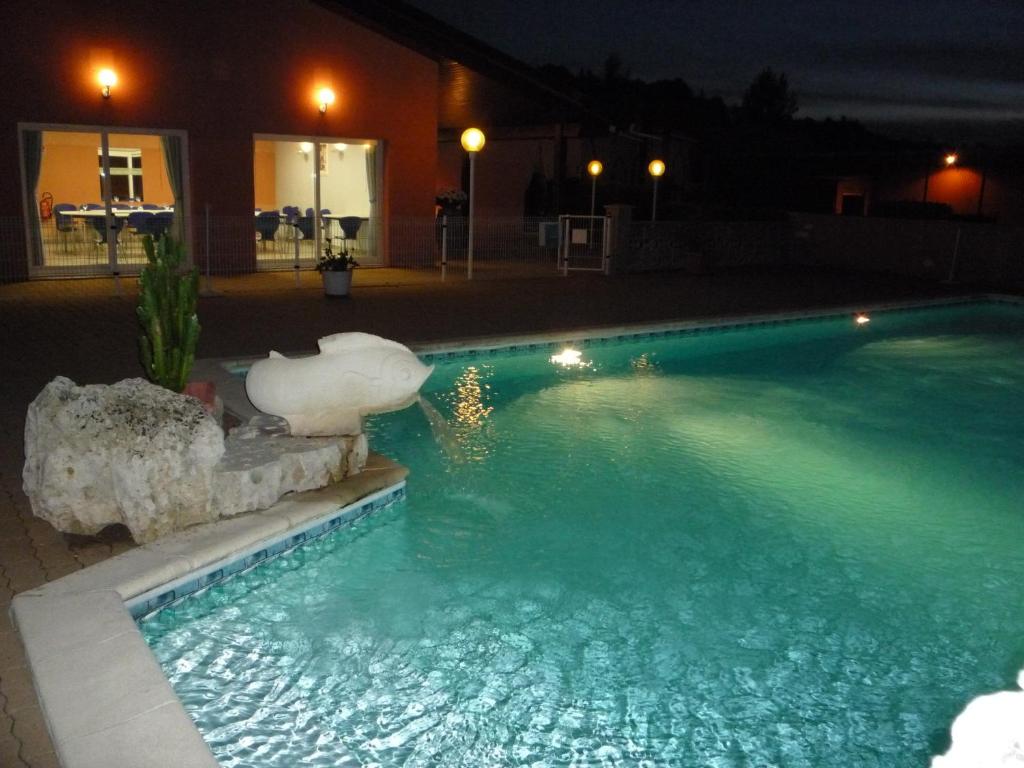 蓬迪卡斯Cit'Hôtel- Hôtel d'Occitanie的夜间游泳池,水中灯火通明