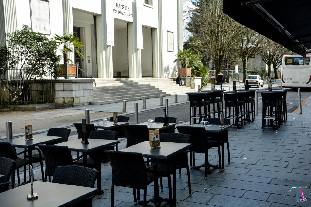 波城Le Matisse Pau Centre的建筑物前的一排桌椅