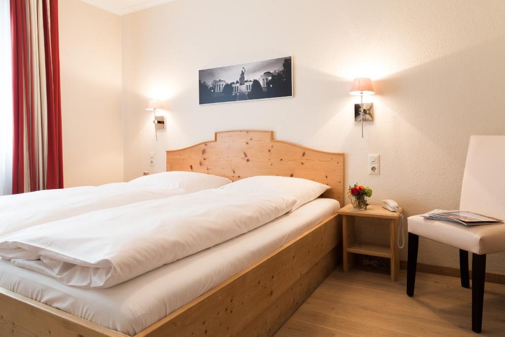 慕尼黑索纳尔霍夫酒店的卧室配有一张白色的大床和一张桌子