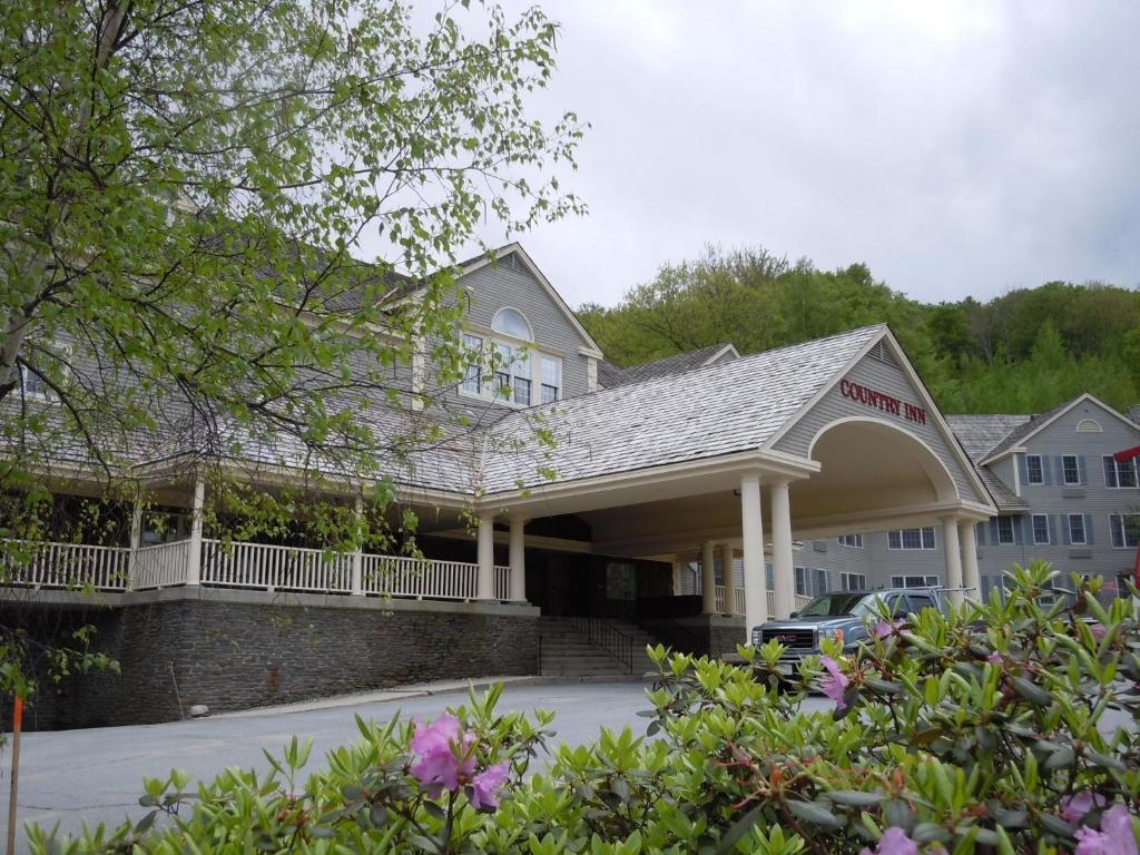 汉考克吉米尼山顶度假酒店的一座旅馆,前面有一座建筑和鲜花