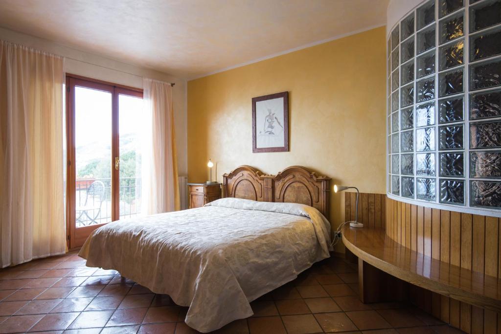 欧斯佩达蒂B&B La Mimosa del Golfo的一间卧室设有一张大床和一个大窗户