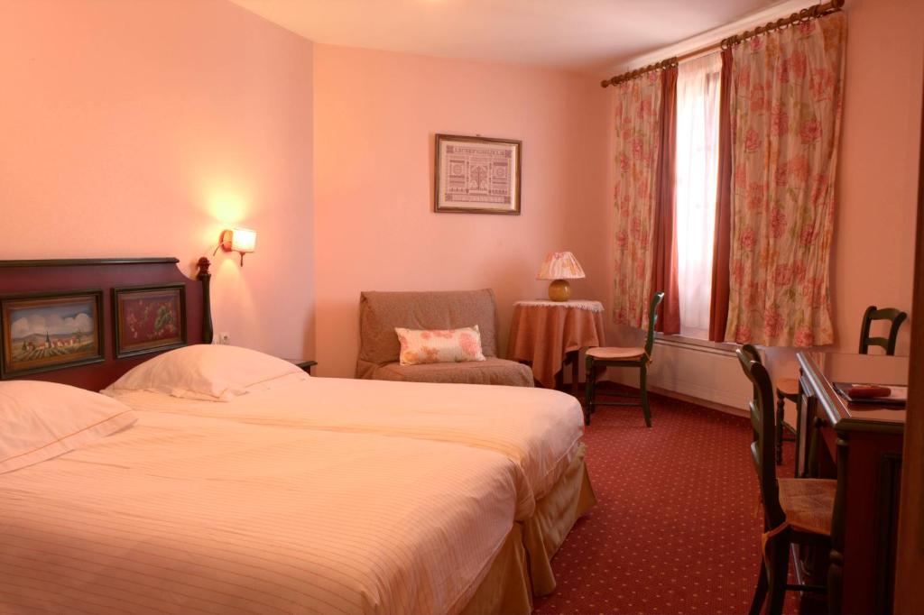 布利安什维莱温泽博格酒店的酒店客房设有两张床和一张桌子。