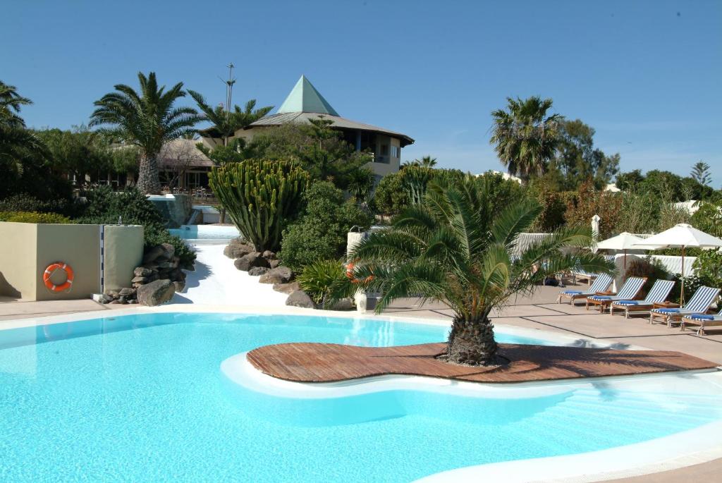 科斯塔卡玛Hotel LIVVO Risco del Gato Suites的中间有一个棕榈树游泳池