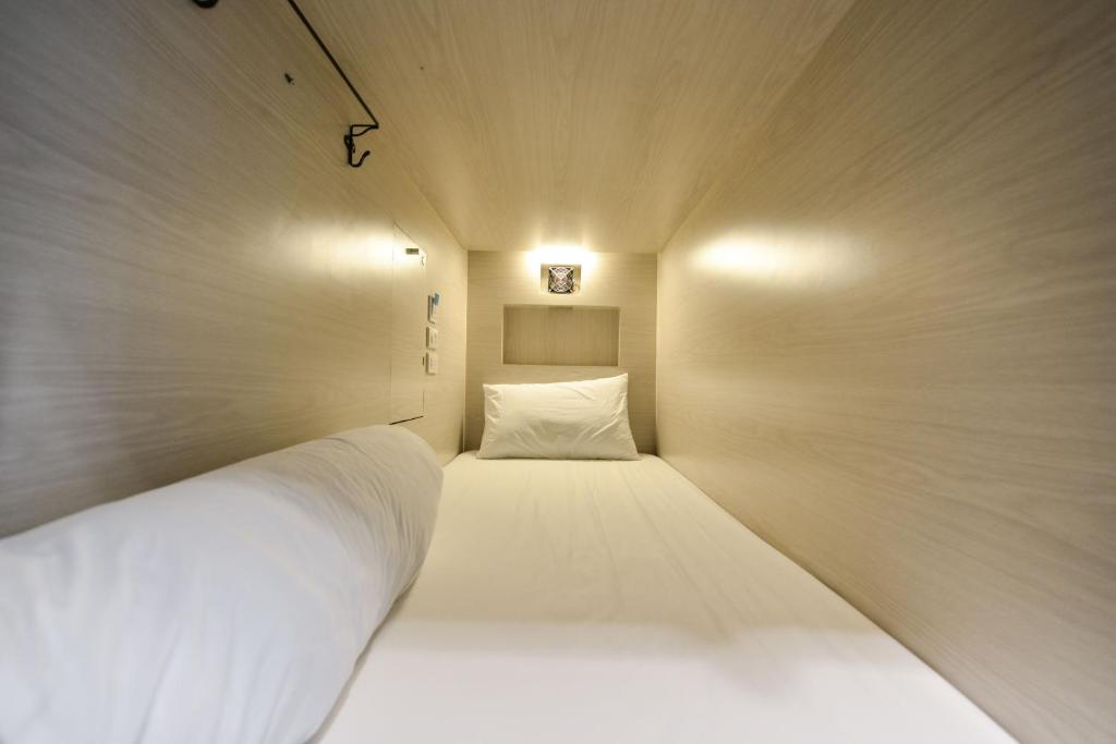 曼谷The Cube Hostel Silom的一间小房间,里面设有白色的床