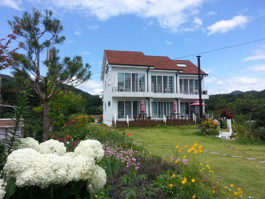 加平天马行空度假屋的前面有鲜花的白色房子