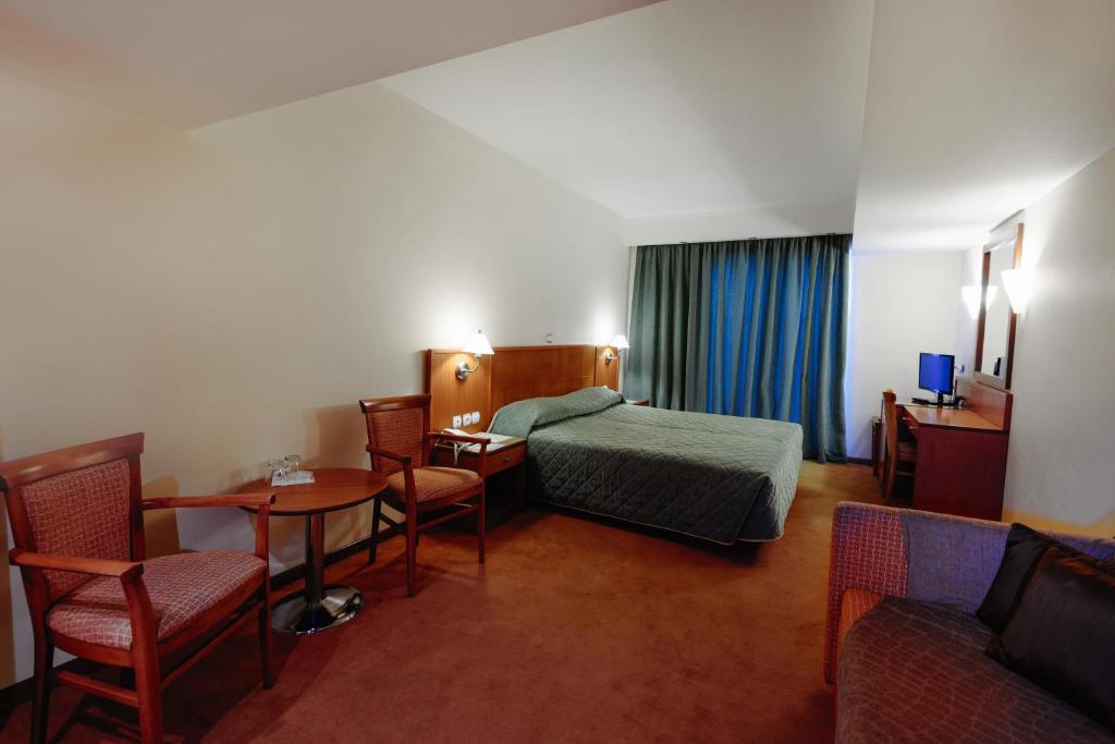 雅典雅典米兰贝洛酒店的酒店客房带一张床、一张桌子和椅子