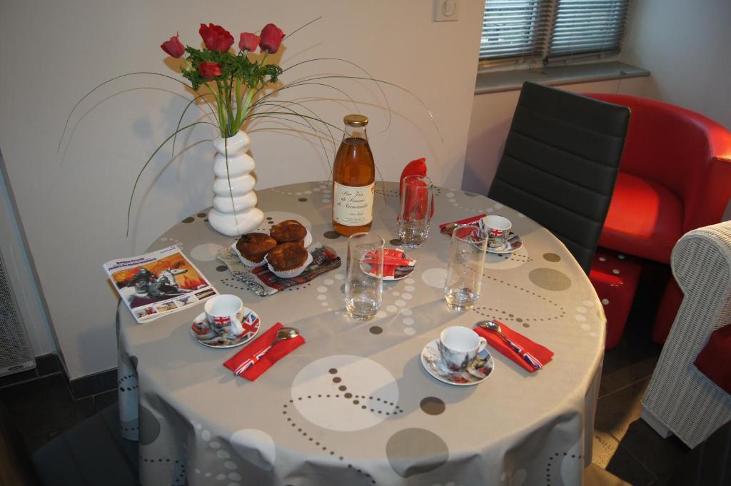 贝叶La Citadine的一张桌子,上面放着一瓶葡萄酒和一瓶鲜花