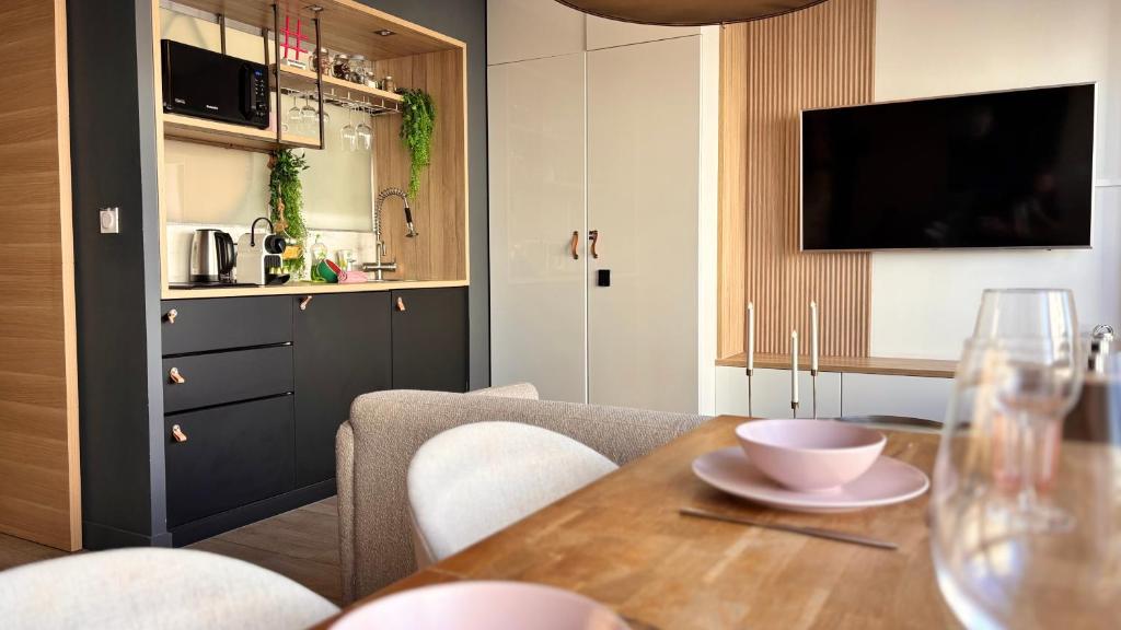 里昂Lost inn Lyon Part dieu -Entre centre ville et gare part dieu -Netflix的配有桌子和电视的厨房和餐厅