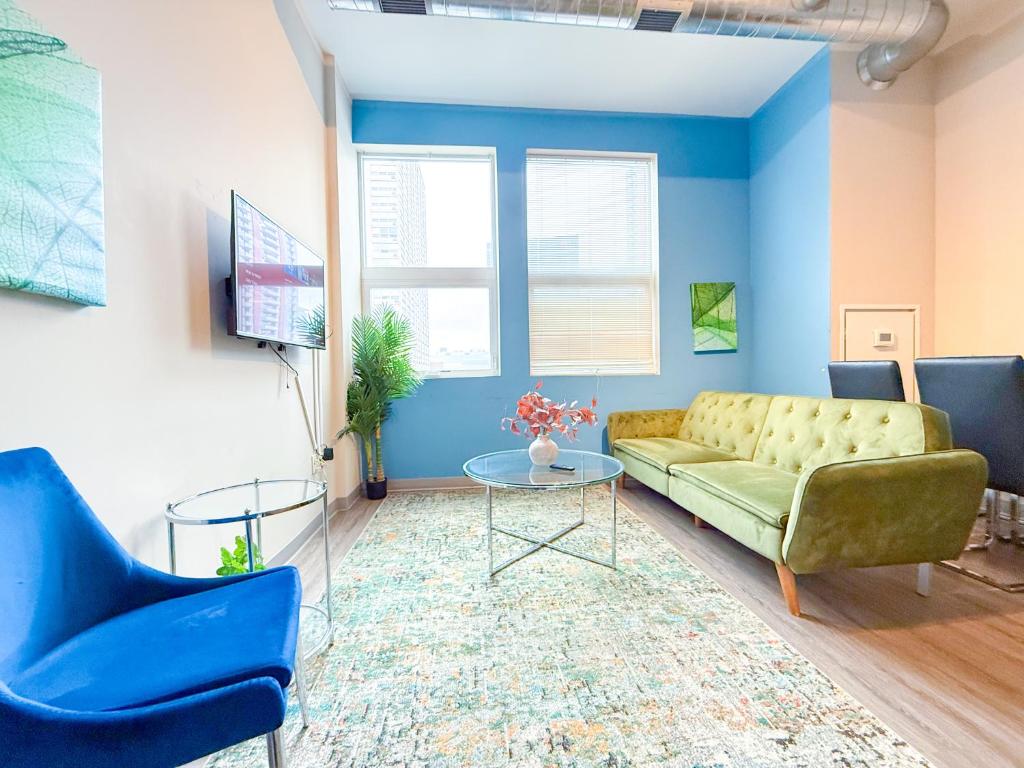 芝加哥Modern 2BR in South Loop Near Soldier Field, Grant Park, Downtown, &amp; Lakefront Trail的客厅设有绿色沙发和蓝色的墙壁。
