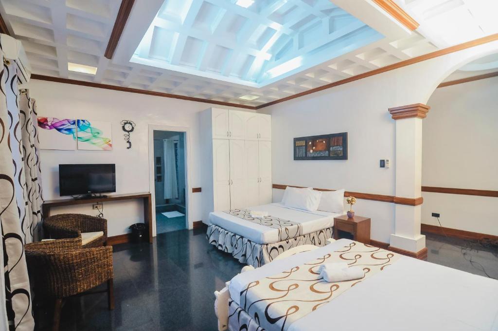 Angono约阿纳别墅度假酒店的一间卧室设有两张床和天窗