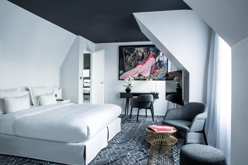 巴黎杰内若酒店的一间酒店客房,配有一张白色的床和一张书桌