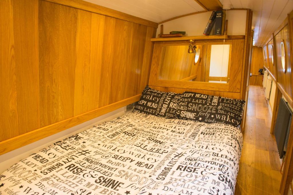 伊利Narrowboat Puzzle的一间卧室设有一张床和木墙
