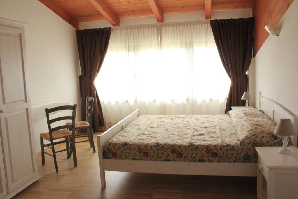 奥扎诺-德尔艾米利亚La Palazzina di Ciagnano的卧室配有床、椅子和窗户。