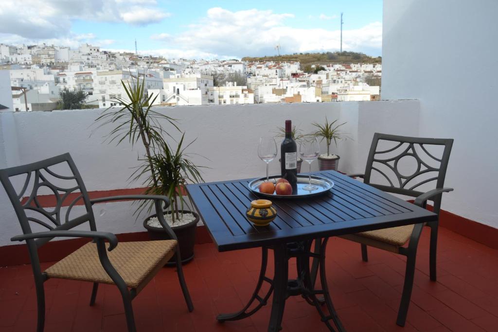 阿尔科斯-德拉弗龙特拉拉方达德尔卡利酒店的阳台上配有一张桌子、一瓶葡萄酒和两把椅子
