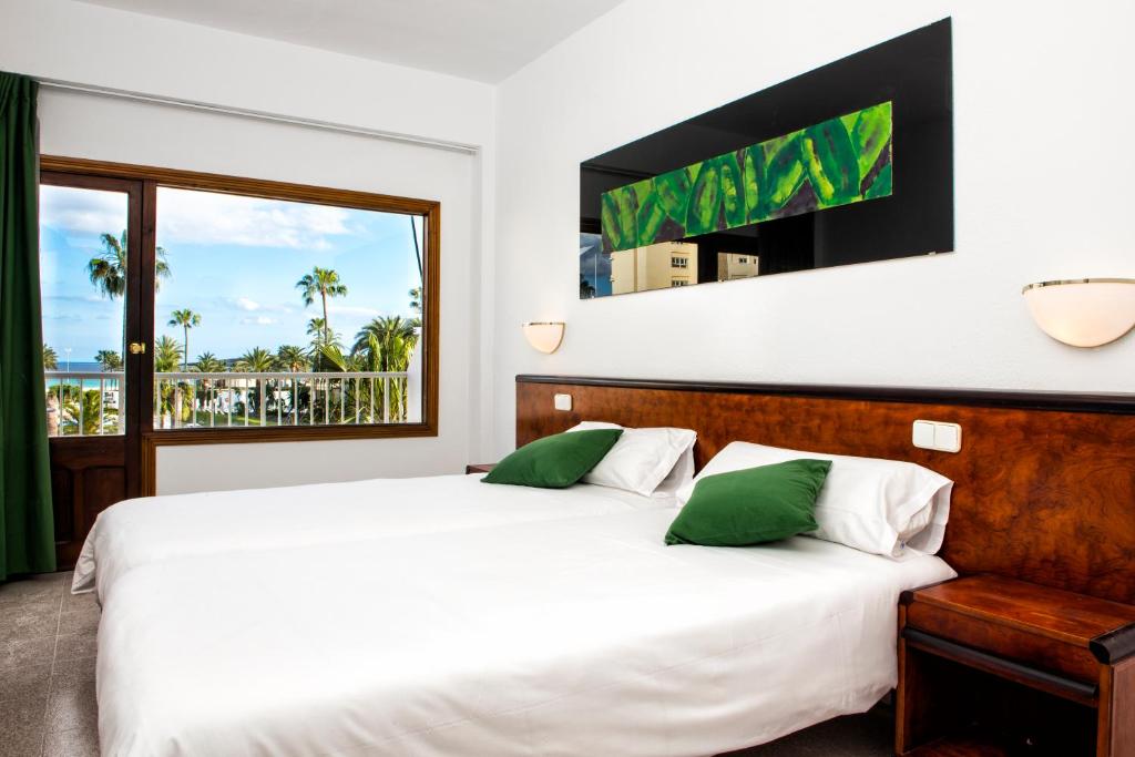 卡拉米洛米尔别墅酒店的一间卧室设有一张床和一个大窗户
