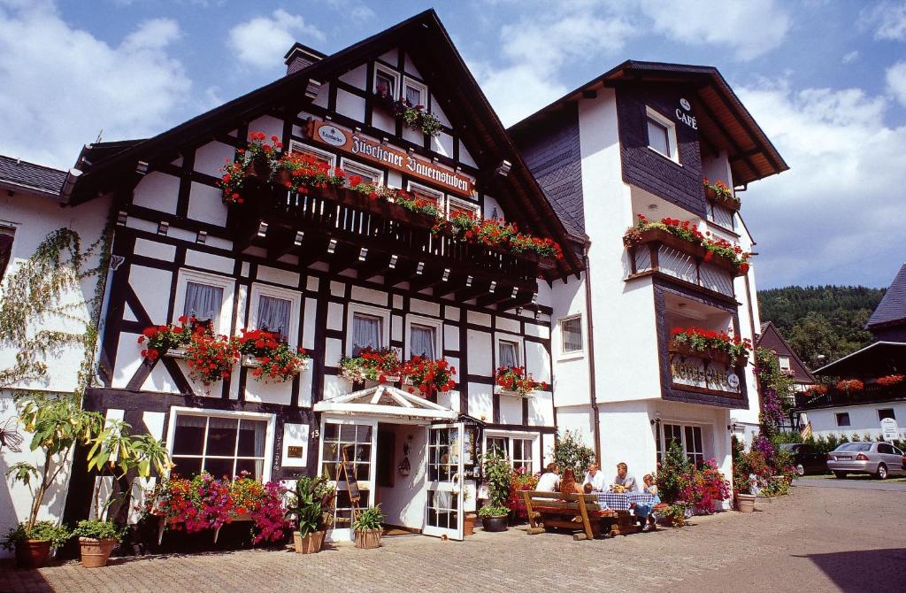 温特贝格宙斯切勒宝恩斯图本旅馆的黑色和白色的建筑,窗户上装有鲜花