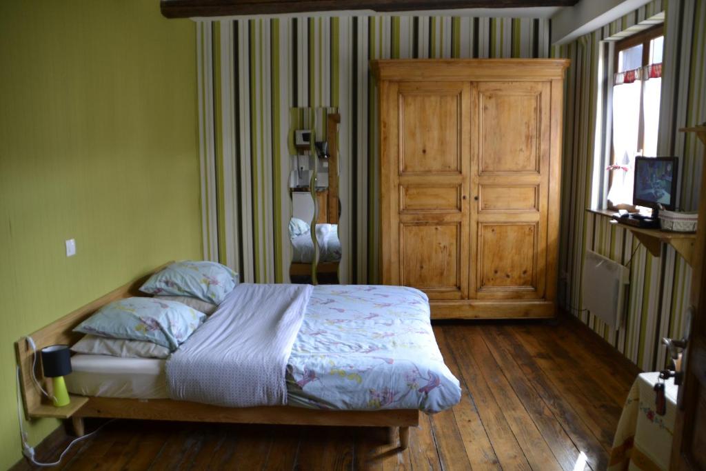凯泽贝尔Gîtes Du Stekala的一间卧室配有一张床,铺有木地板