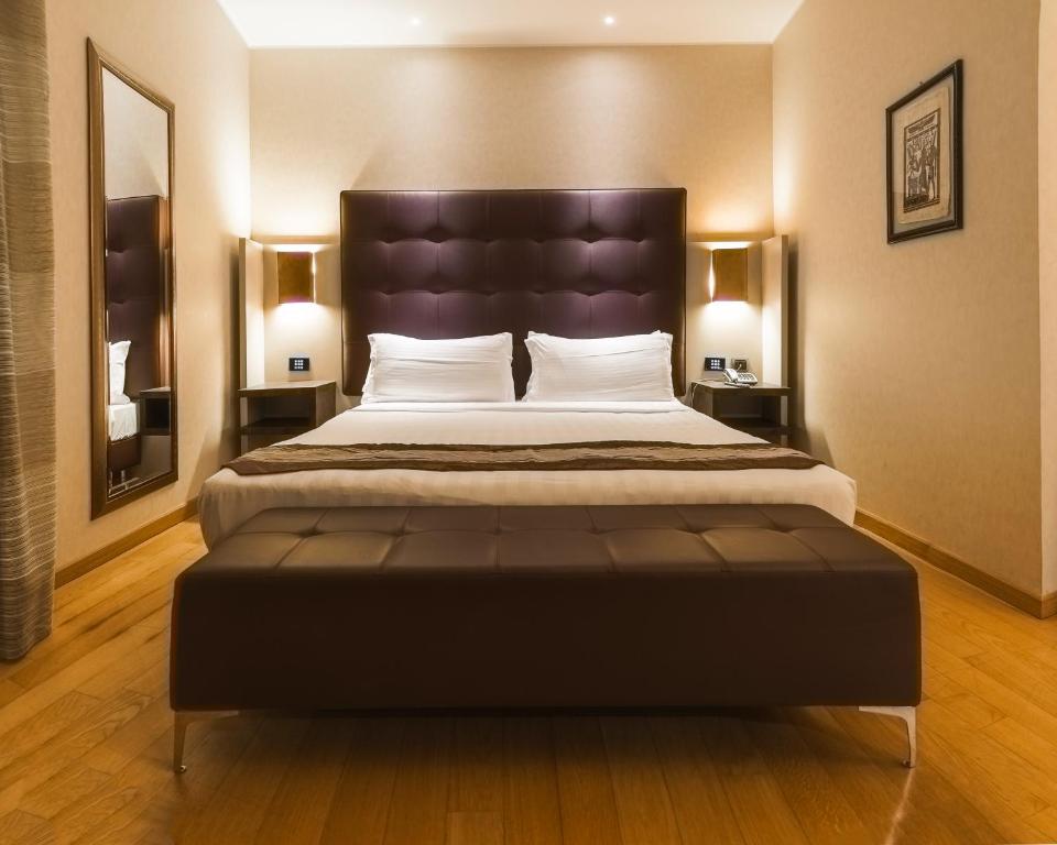 菲乌米奇诺Rome Airport Hotel Fiumicino的一间卧室配有一张大床和大床头板