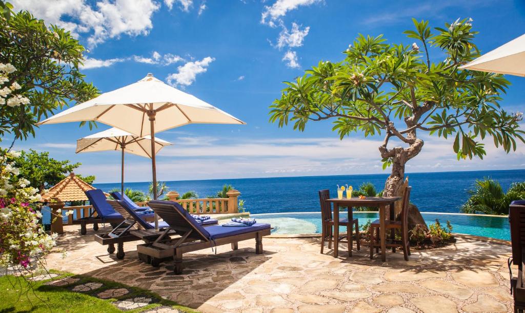 艾湄湾蓝月亮度假酒店的一个带桌椅的海景庭院