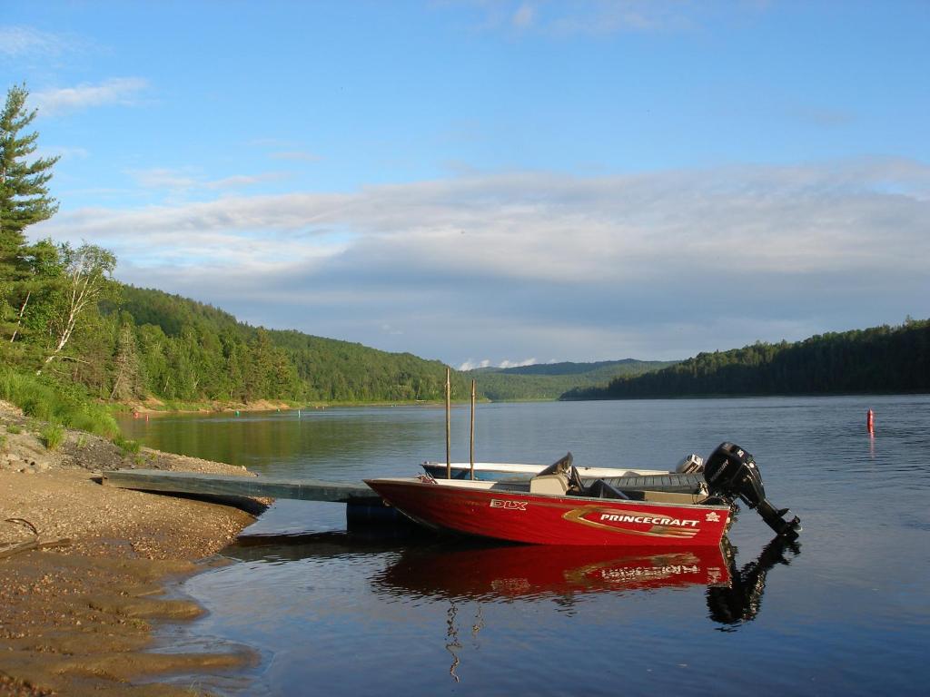 拉图克Chalet Au Bord du St-Maurice的停在湖上码头的红色船