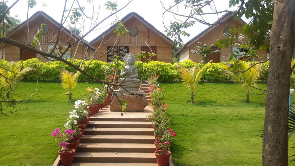 海得拉巴Mrugavani Resort & Spa的一座房子花园中的雕像