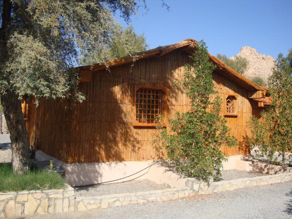 Bilād Manaḩ努尔麦吉露营酒店的前面有一棵树的木屋